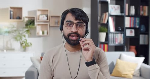 Man with Headset Talking to Camera at Home