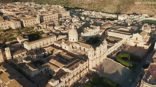 Sunlit City Buildings And Noto Cathedral On A Sunny Day In Sicily, Italy. - aerial pullback