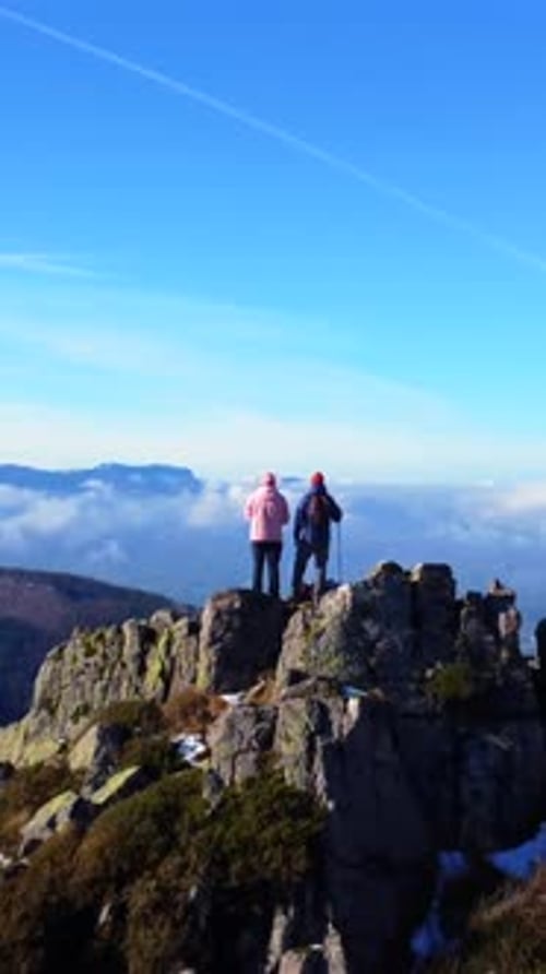 Two men reaching the top of the mountain while trekking