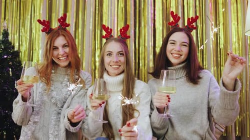 Three Women Celebrating Christmas With Wine And Sparklers