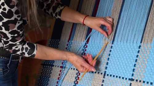 Woman Weaving Colorful Blanket on Wooden Frame with Weaving Needle