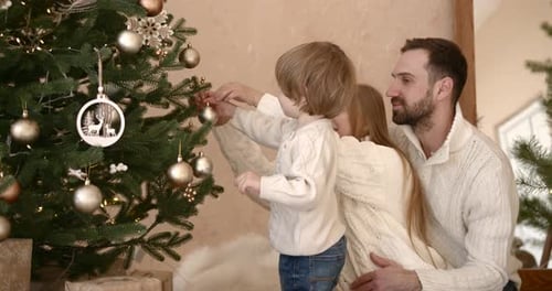 Family with Child Decorating Christmas Tree at Home