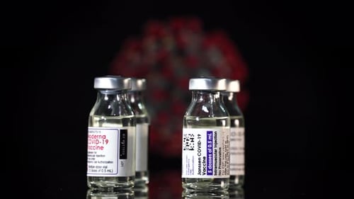 COVID-19 Vaccine Vials on a Black Surface