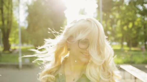 Young Pretty Girl is Happy and Jumps for Joy Park in Bright Summer Day