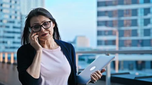 Mature Business Woman Talking on Mobile Phone Modern City Background