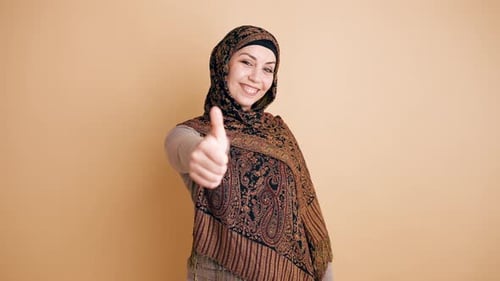 Muslimische Frau im Hijab zeigt Daumen-Hoch-Geste