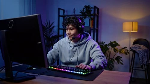 Young Man Gaming on Computer at Night