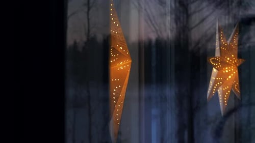 Glowing Star Decorations Hang in Window at Night