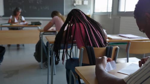 Junger Teenager betrügt während der Prüfung im Klassenzimmer der High School