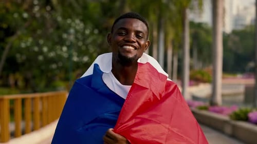 Man Smiling and Waving the Flag in Park