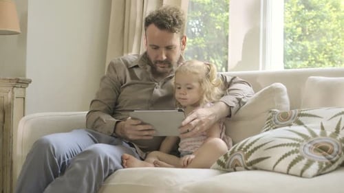 Father and Daughter bonding with digital tablet at home