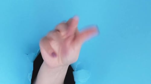 Hand Wags Finger, Beckoning Through Torn Blue Paper