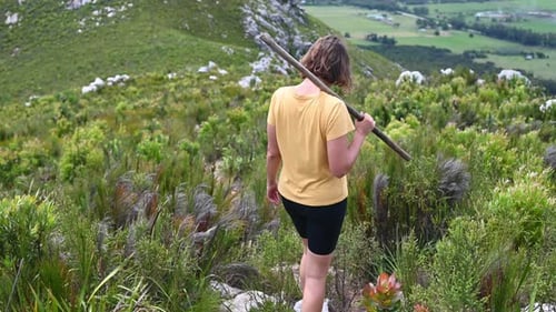 Woman Seen Walking Along Path in Hills