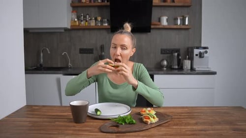 Woman enjoys healthy sandwiches in bright kitchen