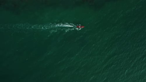 Motor Vessel with People Inside is Swimming in Ocean of Aquamarine Color Filmed By Drone