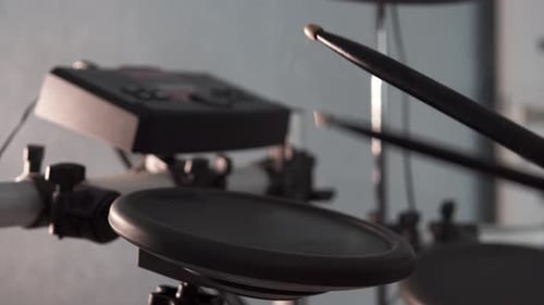 A drummer plays an electronic drum kit in a music studio. Drumming lesson.