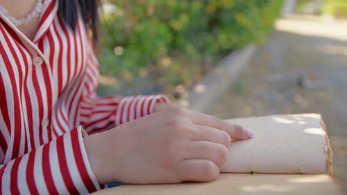 Woman Reads Old Book in Sunny Park