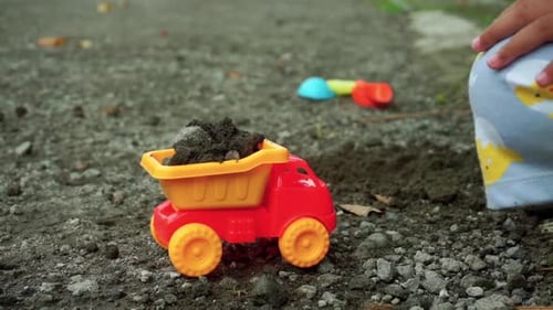Child Playing with Toy Dump Truck