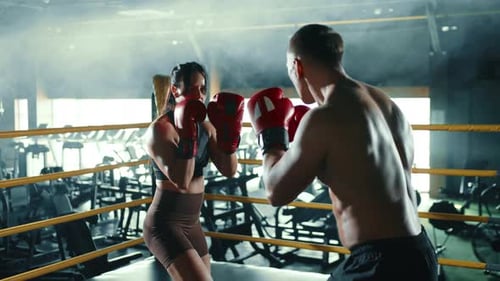 Young Female Boxer and Trainer Practicing Punches in a Professional Boxing Gym