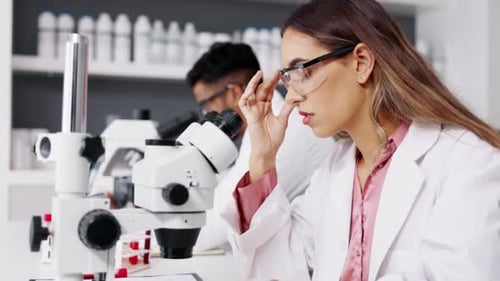Scientist Working at Microscope in Modern Lab