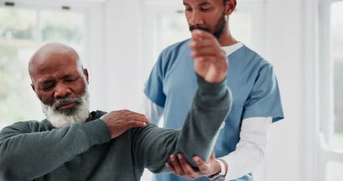 Senior Man Receives Arm Examination by Doctor