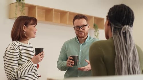 Coworkers chatting during a coffee break in office