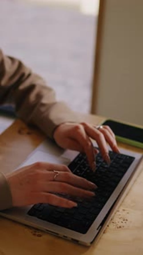 Woman Typing on Laptop at Desk Indoors