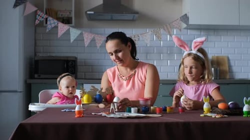 Mother and Daughters Decorating Easter Eggs Together