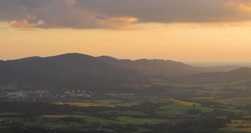 View of a mountainous landscape during sunset when the rays shine through the landscape lying over t
