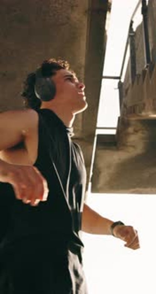 Fitness, man and stretching with headphones in city for post workout, cardio fatigue and recovery