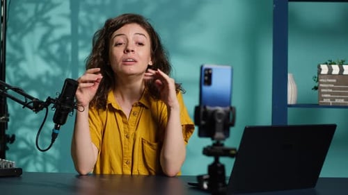Woman Vlogging at Desk with Microphone and Phone