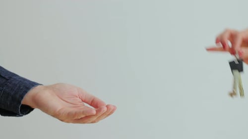 Close Up of Male Hand Passing Key to Female in New Apartament
