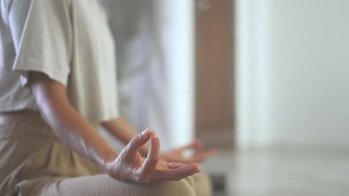 Happy girl doing morning practice in modern living room. Close up of Woman in lotus pose meditate