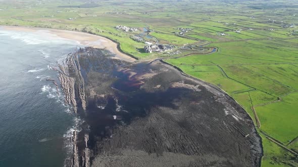 High aerial dolly shot overhead Doughmore Bay with Trump Doonbeg ...