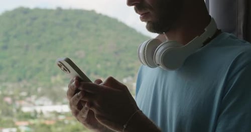Cropped View of a Young Relaxed Man Using Mobile Phone Checking Content Networking Scrolling Feed