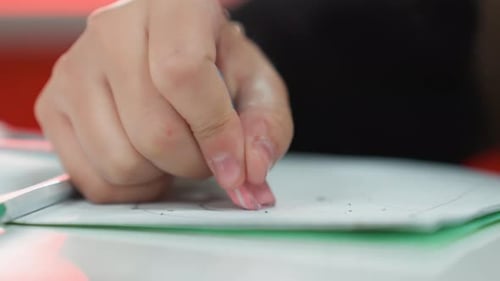 Konzentrieren Sie sich darauf, dass der Schüler den Radiergummi für ordentliche Hausaufgabenkorrekturen verwendet. Detaillierte Ansicht des Radiergummis beim Drücken