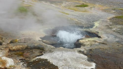 Ein heißes Quellfeld plätschert aus der aktiven Vulkanlandschaft Islands, statischer Blick von oben - Hveravellir