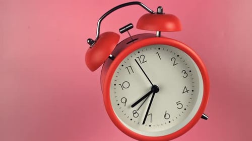 The Alarm Clock Flies Up on a Pink Background Filmed on a Highspeed Camera at 1000 Fps