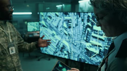 Female Army Command Center Strategist Operating Satellite Surveillance on Tablet