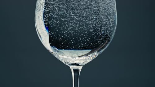 Sparkling Water Bubbles in Glass on Dark Background