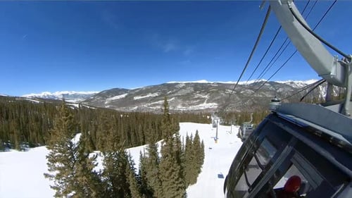 Snowy mountains viewed from outside of gondola while carrying skiers and snowboarders to the top of