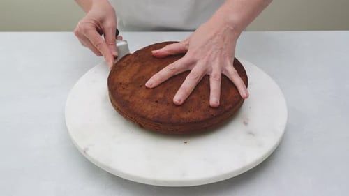 Chocolate cake sliced in into two layers close up on kitchen table.