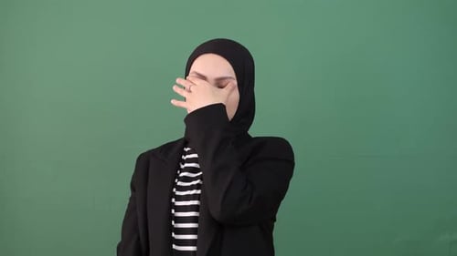 Woman Performs Neck Stretches on Green Background