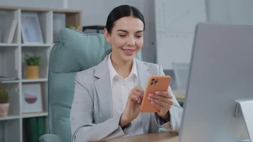 Smiling Businesswoman Using Smartphone in Modern Office