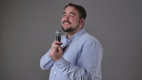 Man Smiling and Speaking Into Microphone Giving Presentation