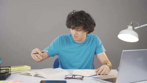 Frustrated Student Studying at Desk Indoors
