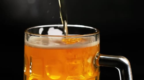 Beer Being Poured Into a Glass Mug