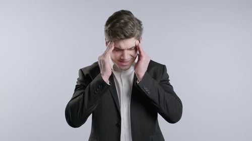 Stressed Man in Suit Rubbing Temples