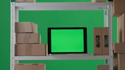 Le cadre est sur fond vert et représente une pièce vide avec des styles sur lesquels se trouvent des boîtes et un