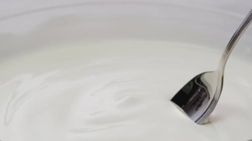 White Creamy Sauce Texture Closeup Dip a Spoon Into White Yogurt Macro Dairy Products Concept